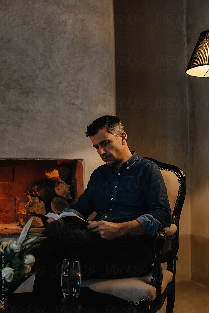 Handsome Caucasian Man Reading Book By Fire By Visualspectrum