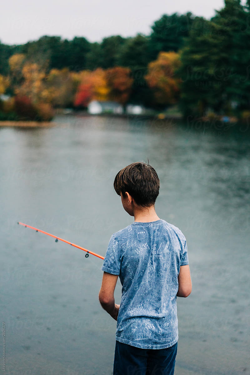 boy fishing in lake in the fall