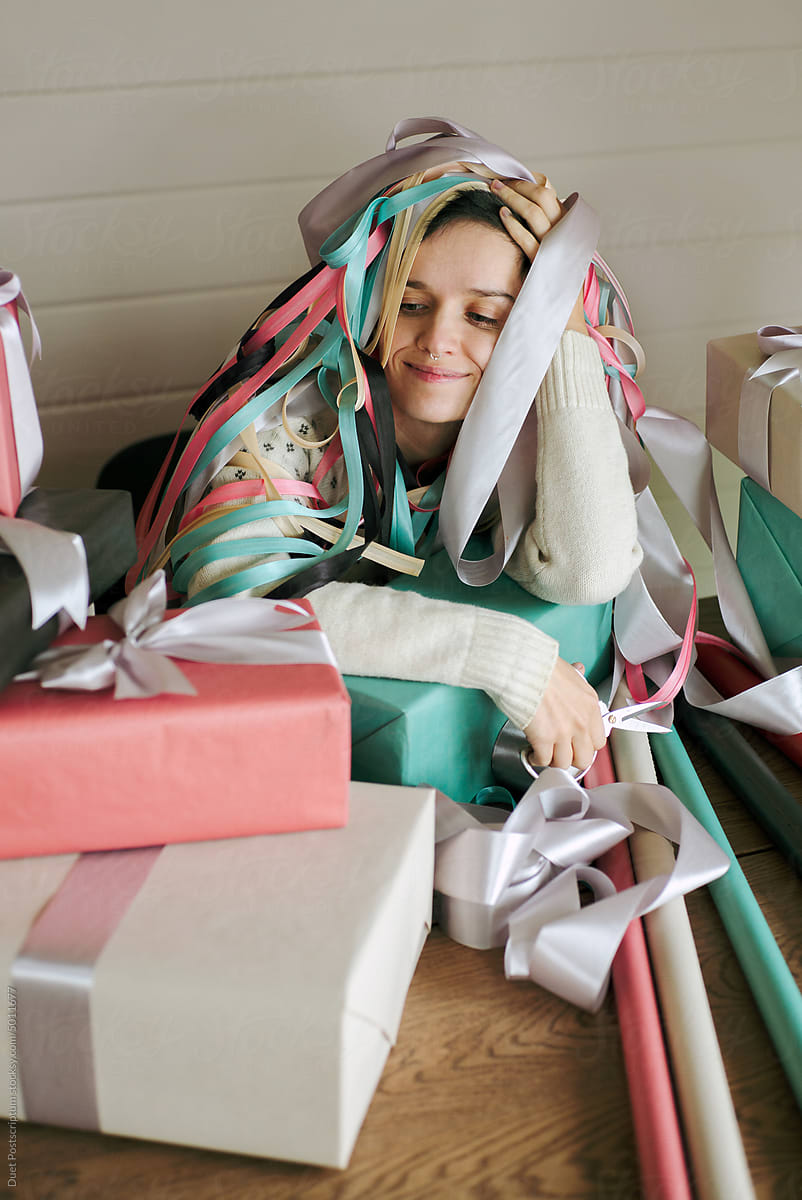 Young woman resting after wrapping Christmas gifts.