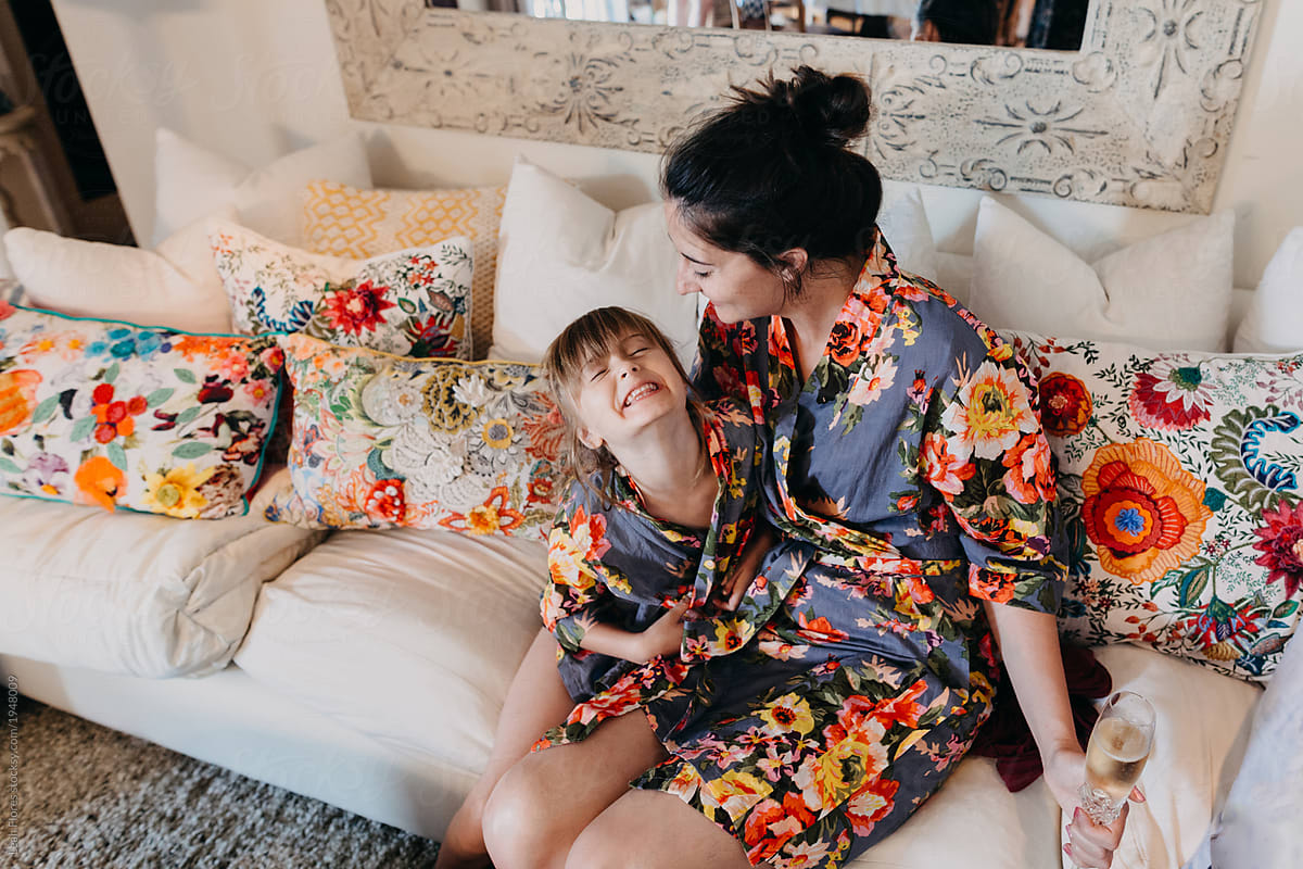 Mother And Daughter Sitting On Couch By Leah Flores