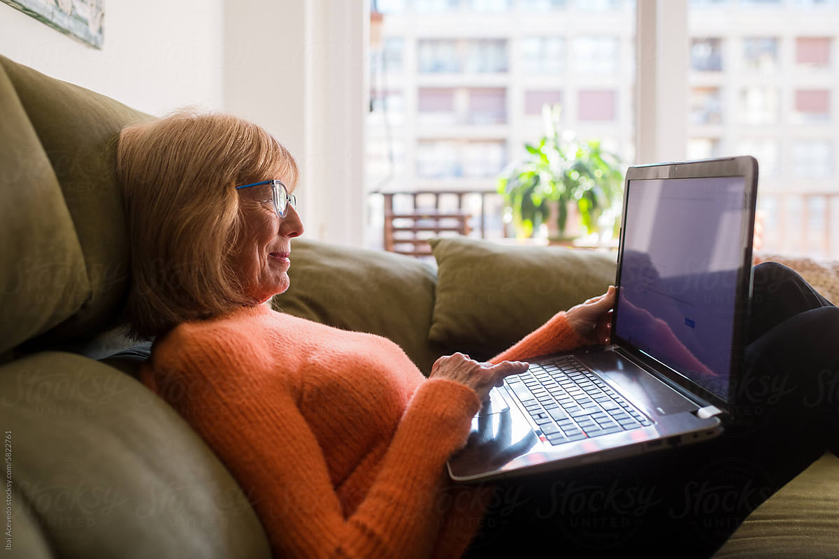 Mature woman shopping online on sofa