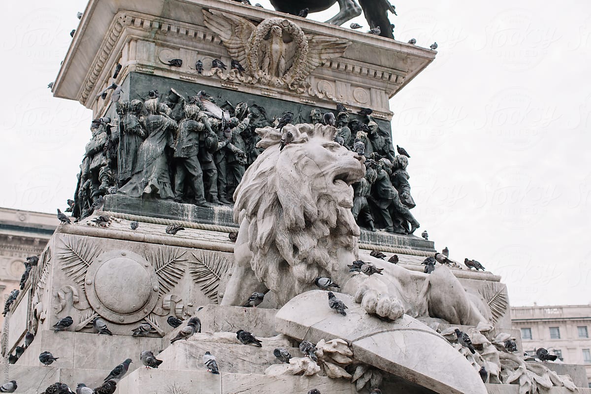 Statue of lion in Milan with lots of pigeons