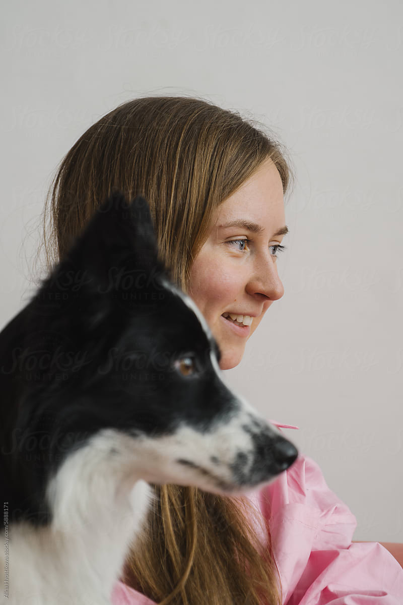 Young woman with Border Collie dog at home