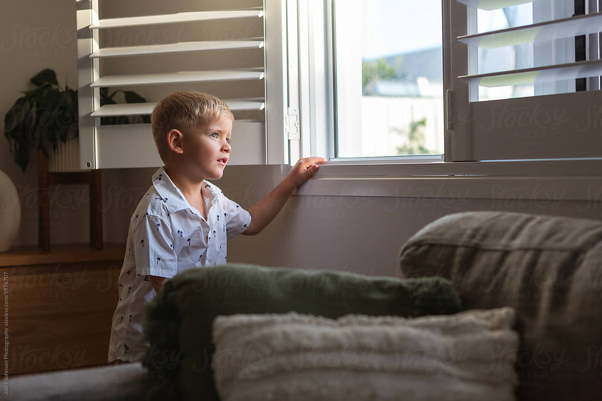 Young boy staring out a window