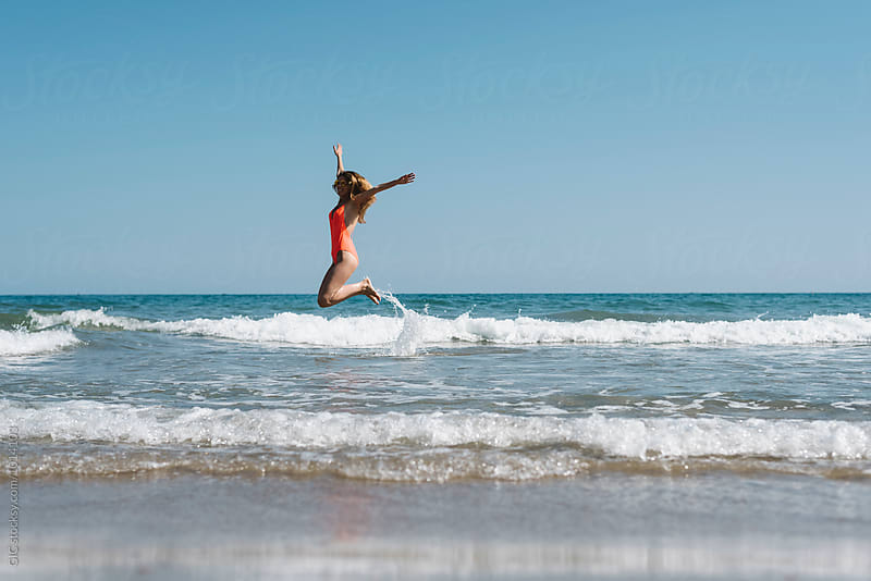 Young woman jump over the waves