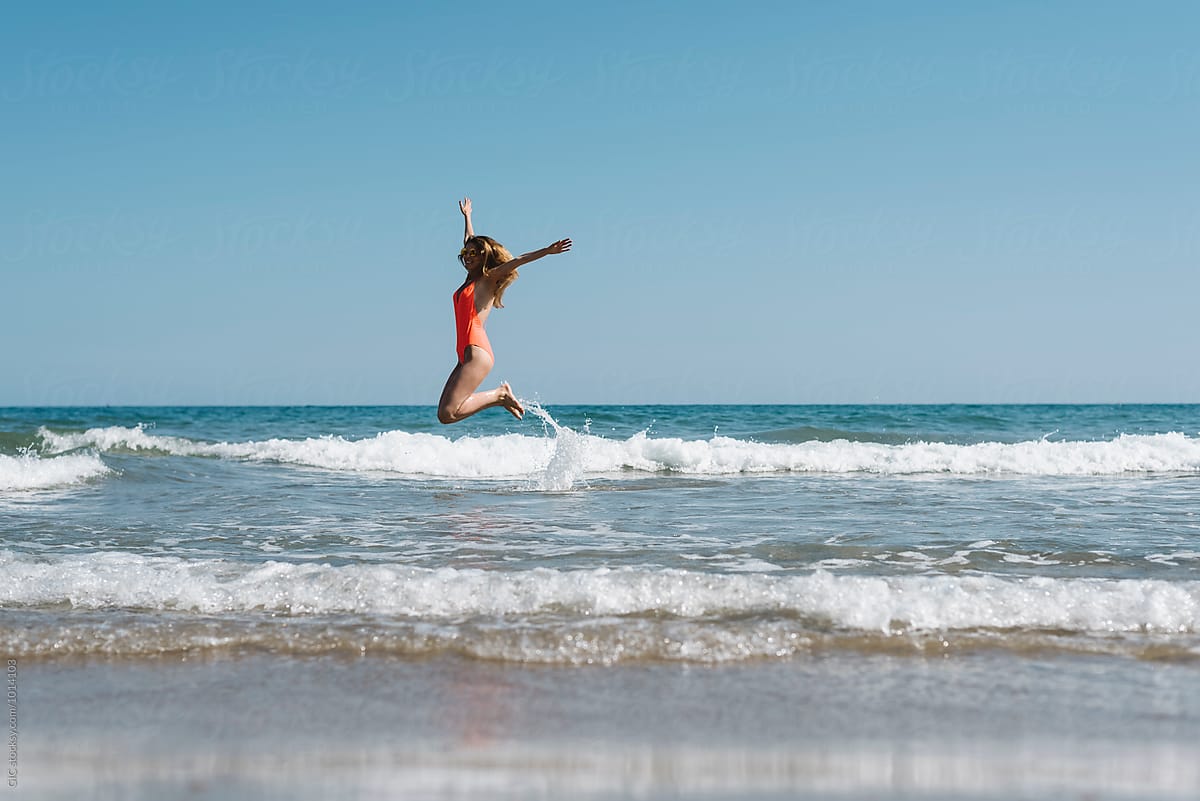 Young Woman Jump Over The Waves By Simone Wave Happy Jump Stocksy United