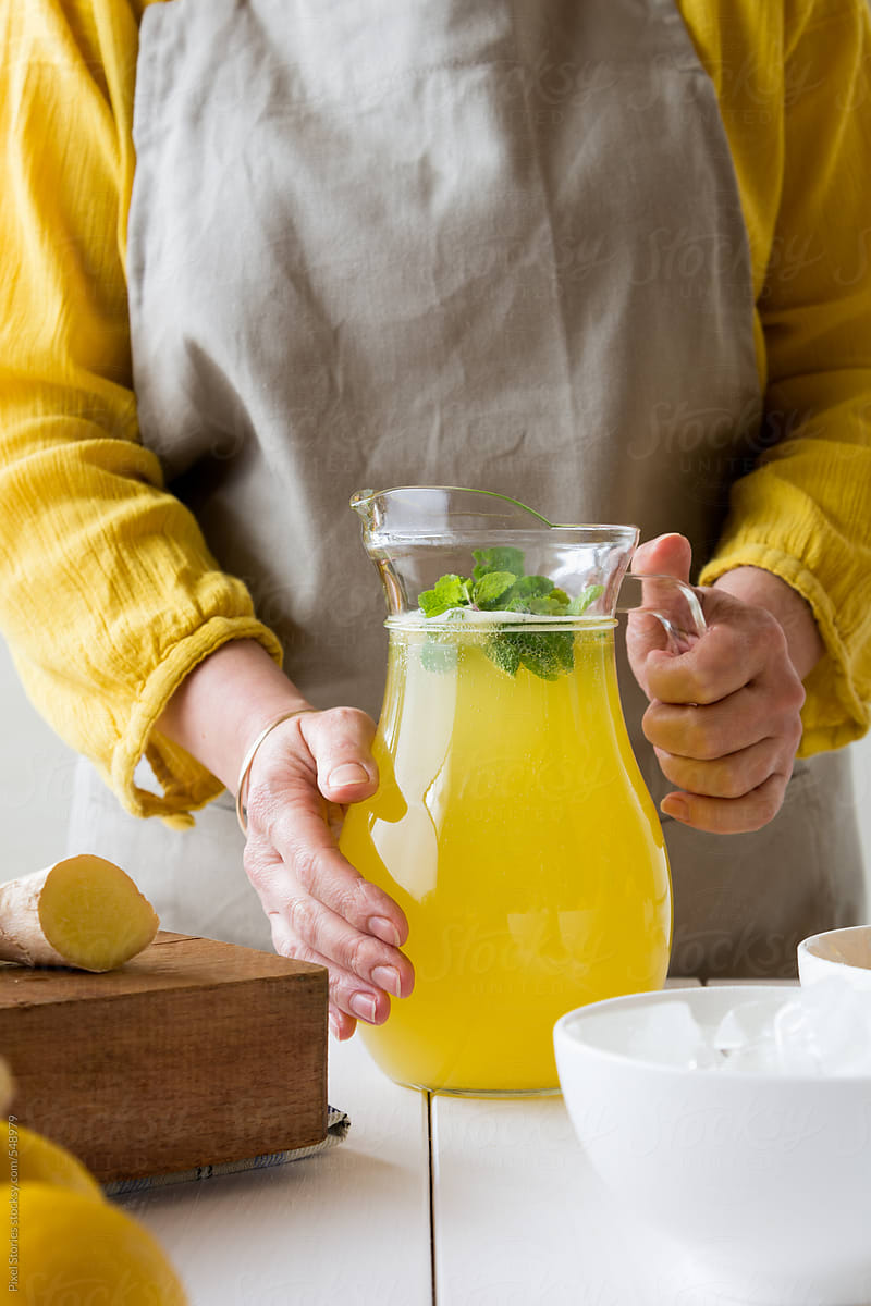Drinks: woman holding jug with ginger lemon fizz
