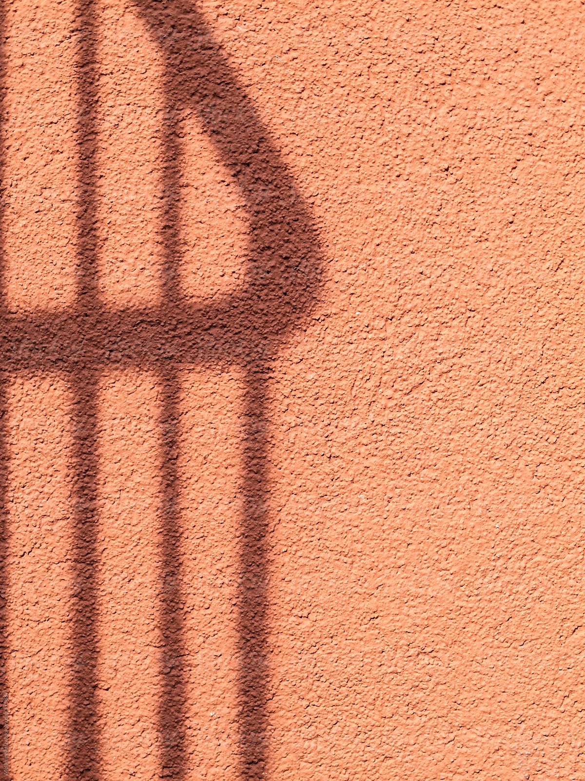 Shadow of a railing on a red wall
