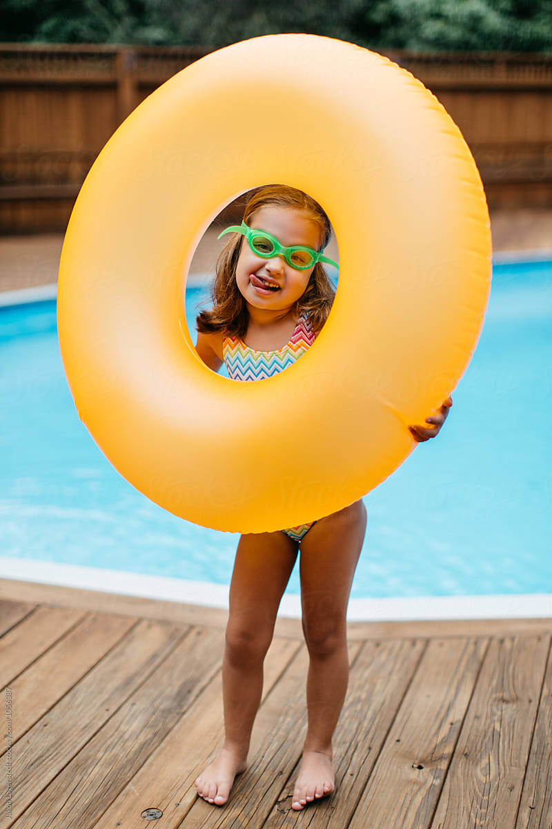 Cute Young Girl Playing With Her Inner Tube By A Pool By Stocksy 