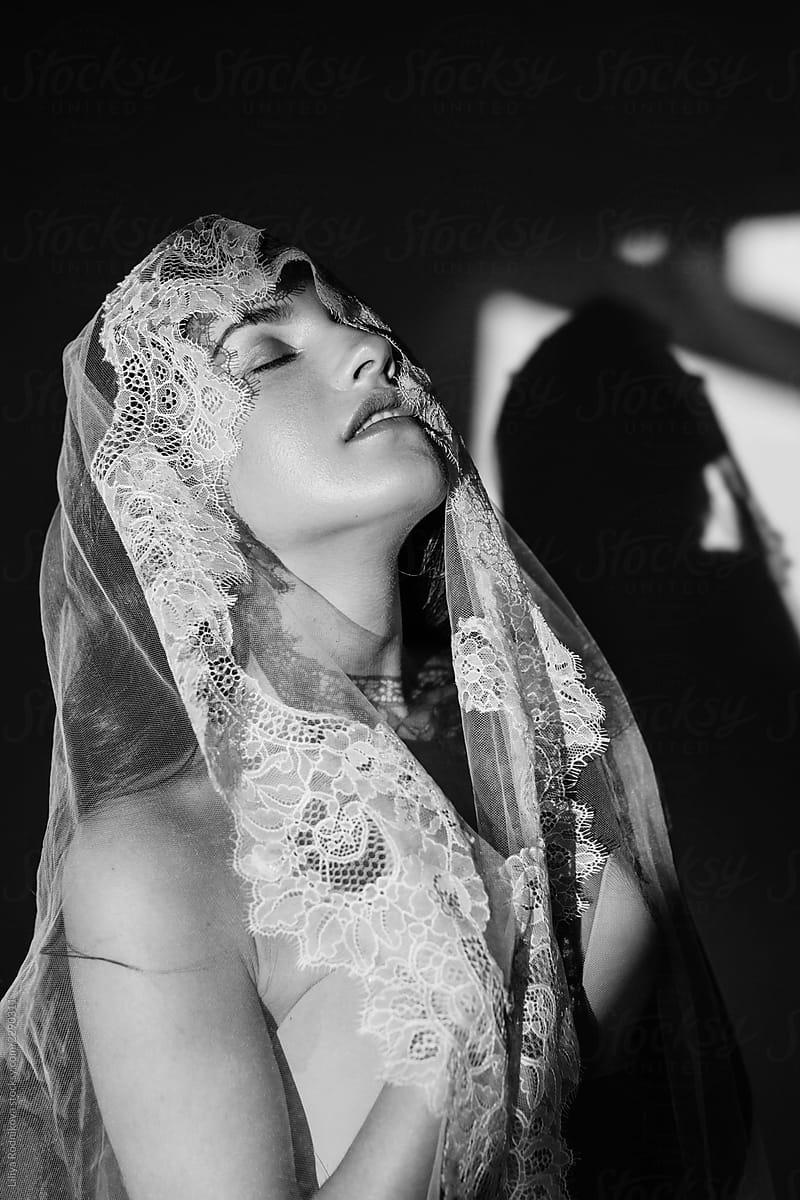 Monochrome portrait of daydreaming bride under the veil