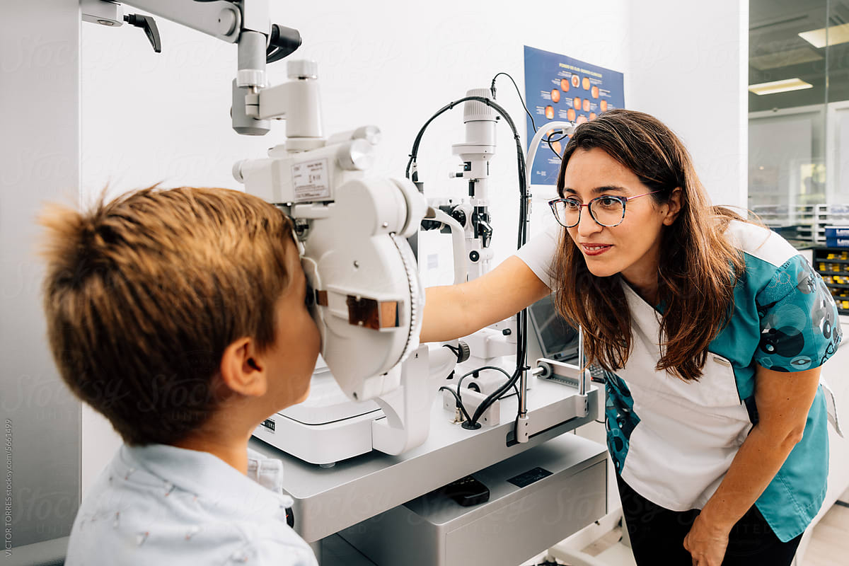 Female doctor examining eyesight of kid