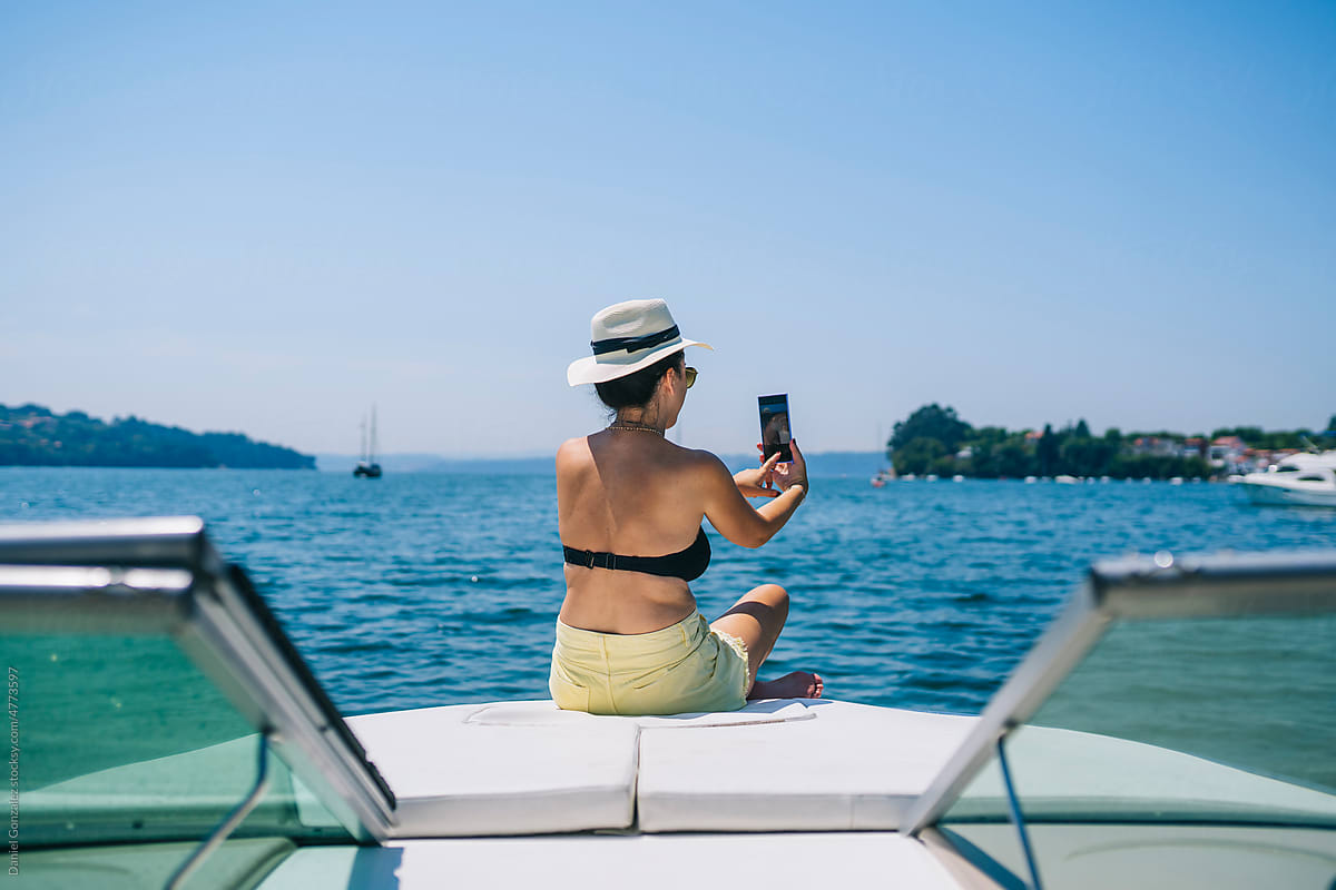 Young woman taking selfie on boat floating in sea
