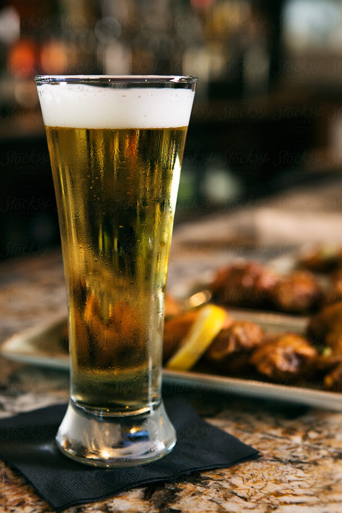 Restaurant: Tall Glass Of Beer In Front Of Chicken Wings