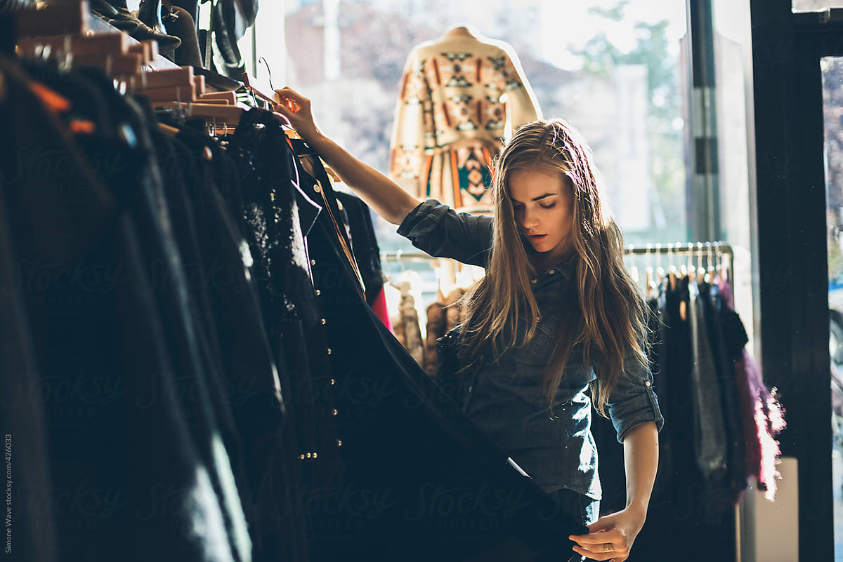 Young woman in a vintage shop looking for the right dress