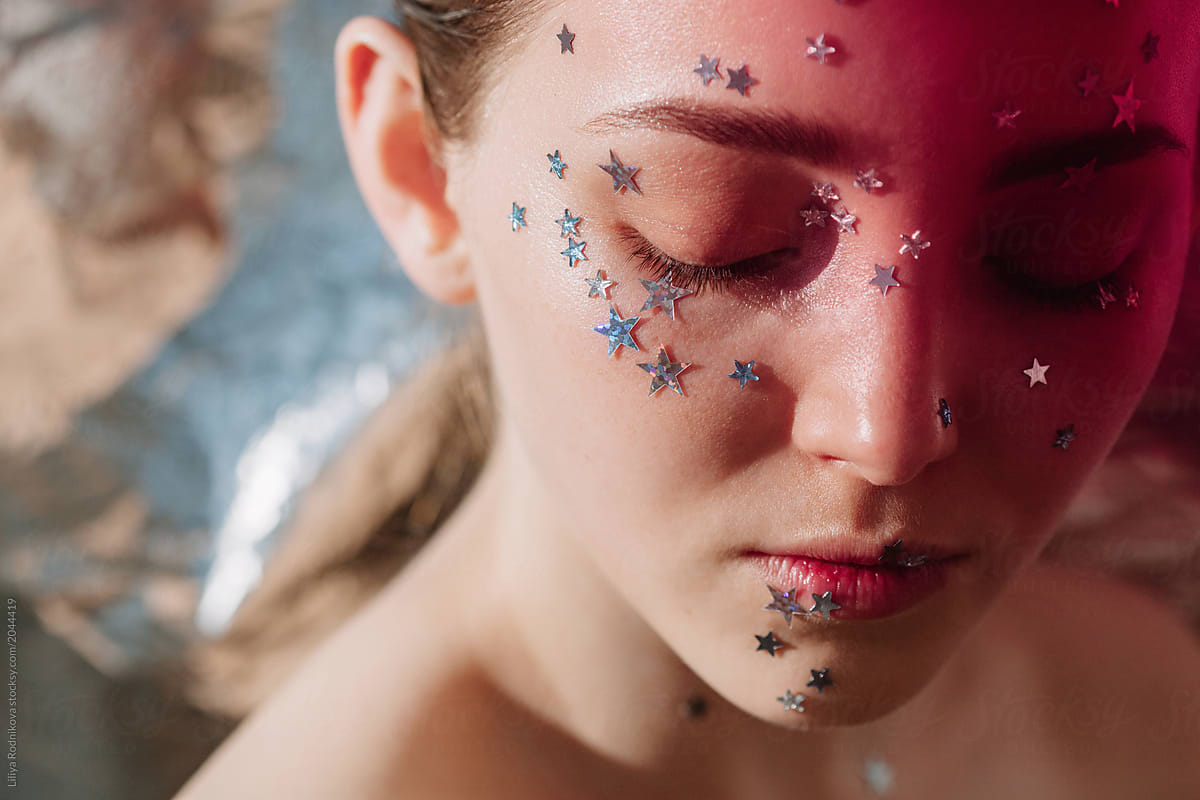 Closeup portrait of pretty girl with silver stars on her face