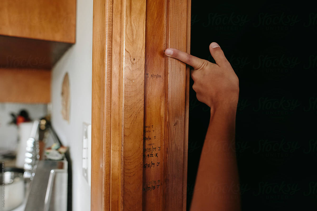 Child points at his height marked on doorframe