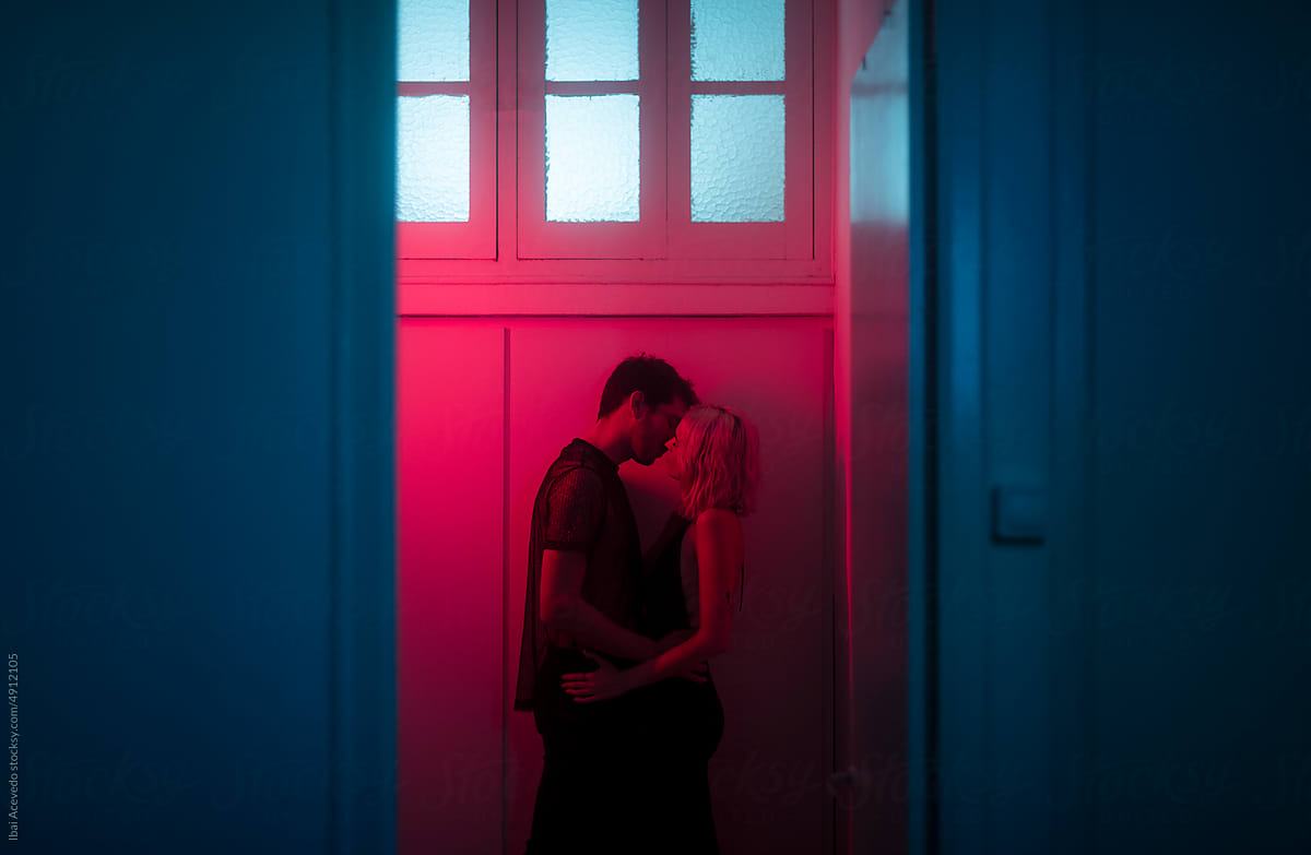 Surreal portrait of kissing couple in night club