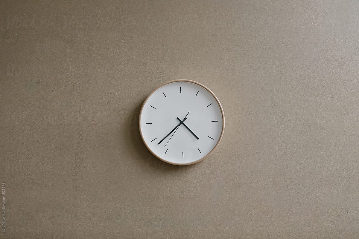 modern minimal analog clock on tan wall