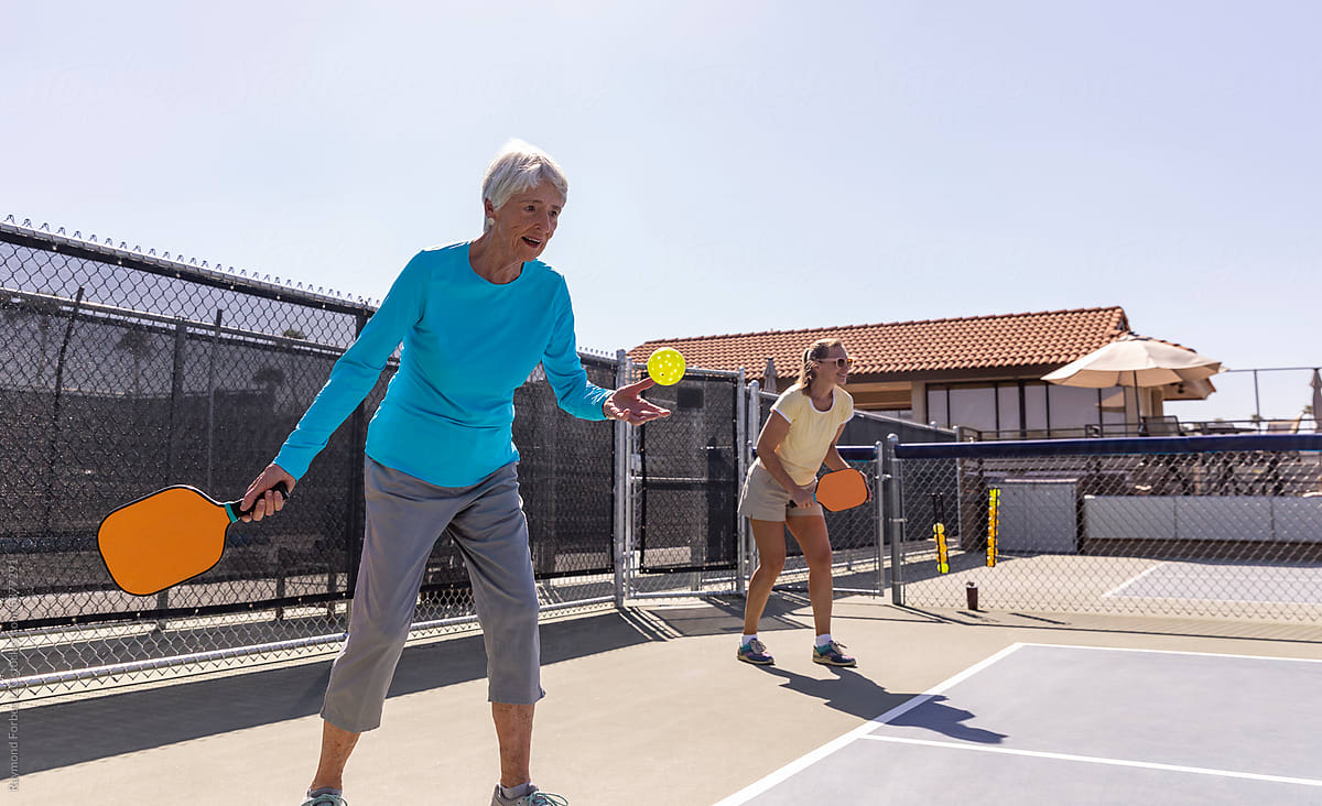 Partners match on outdoor Pickleball court  with raquet