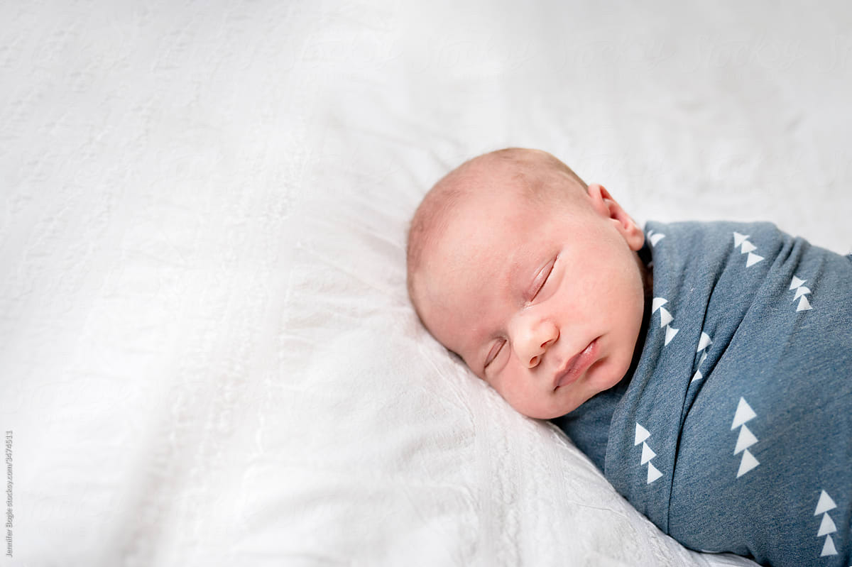 Infant sleeping on white coverlet