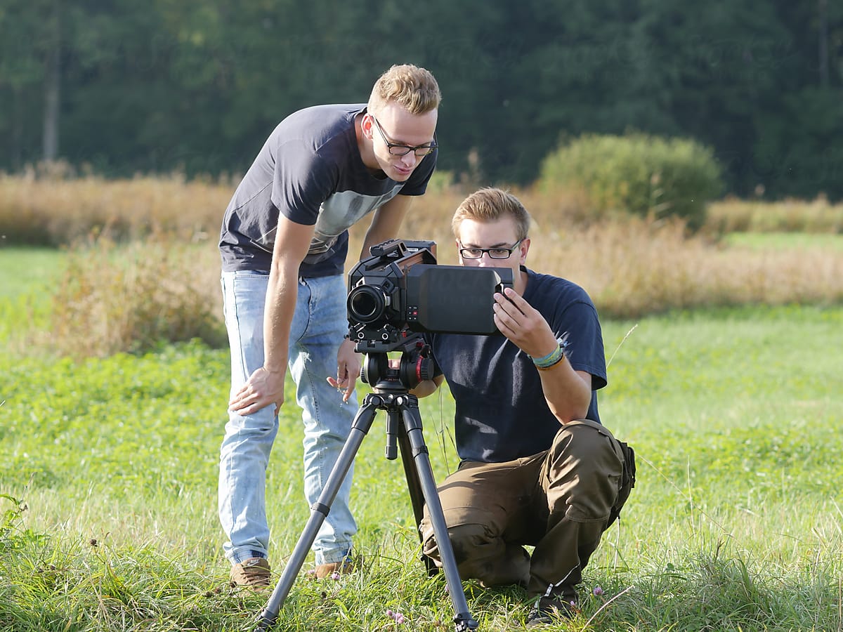 Two young students practicing to make film on field