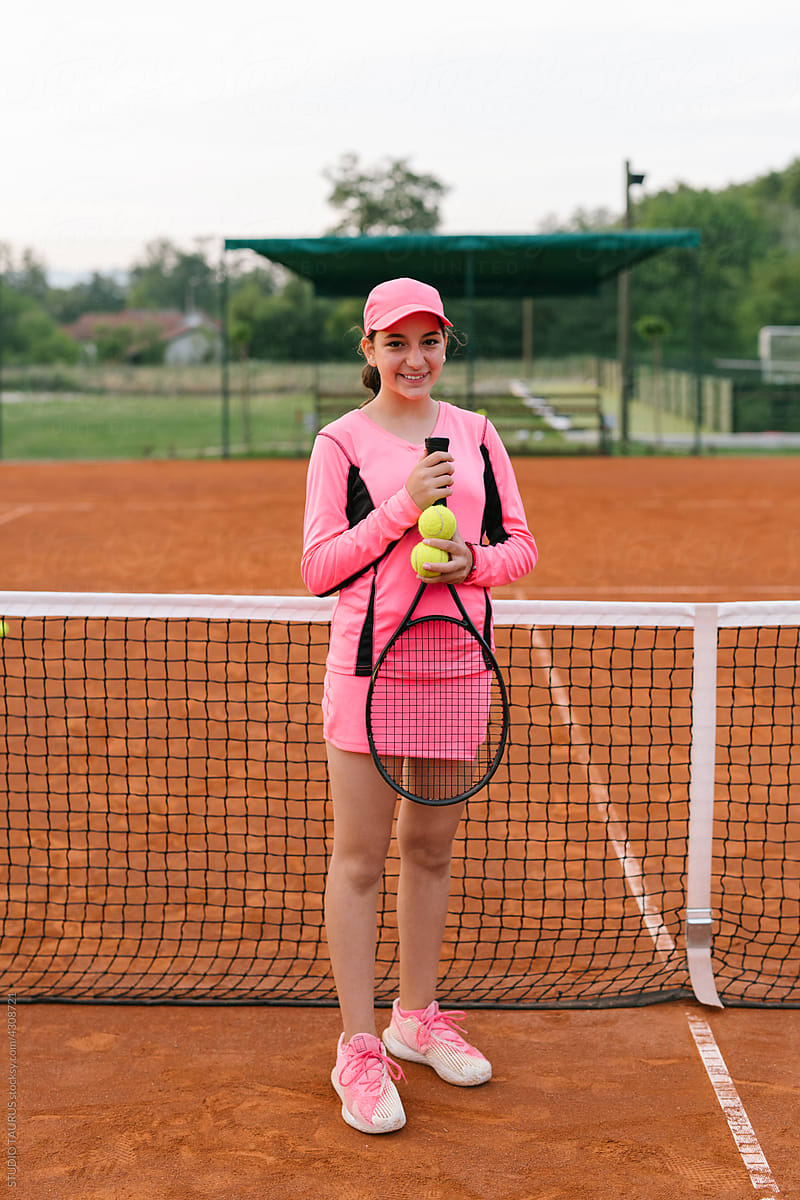 Portrait of smiling young girl on a tennis court