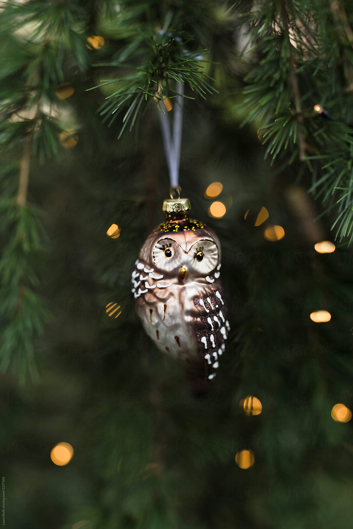 Glass owl decoration close to Christmas lights
