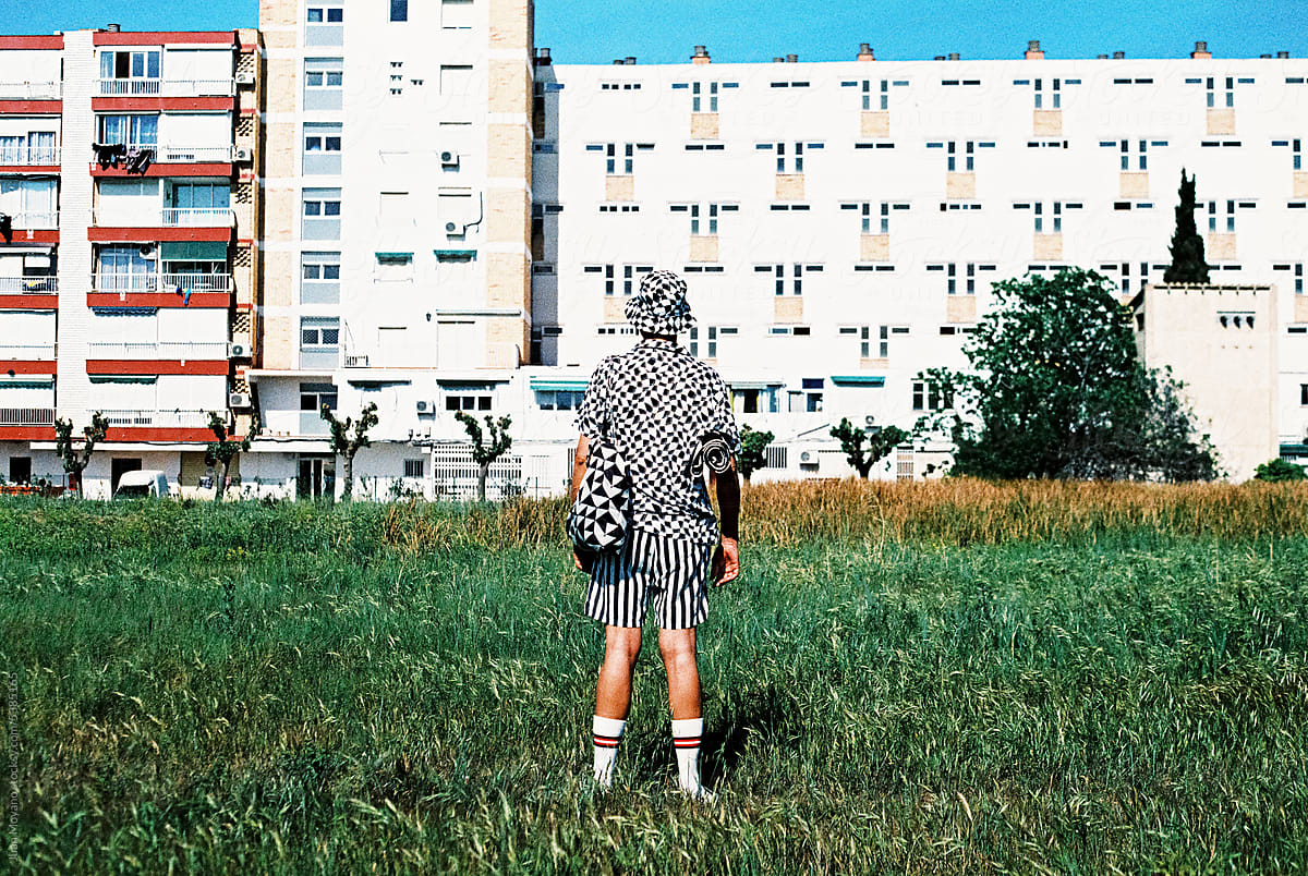 man stands in front of an apartment block, 35mm film