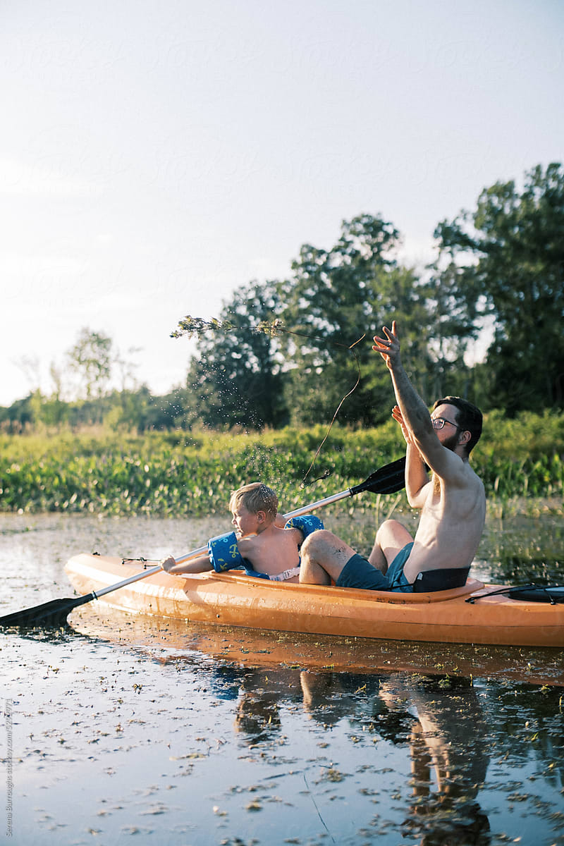 father and son kayaking together in a kayak on a river