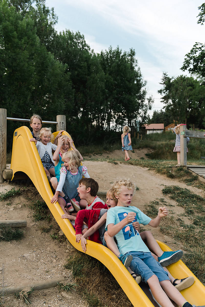 stock photo of group kids coming down a slide together