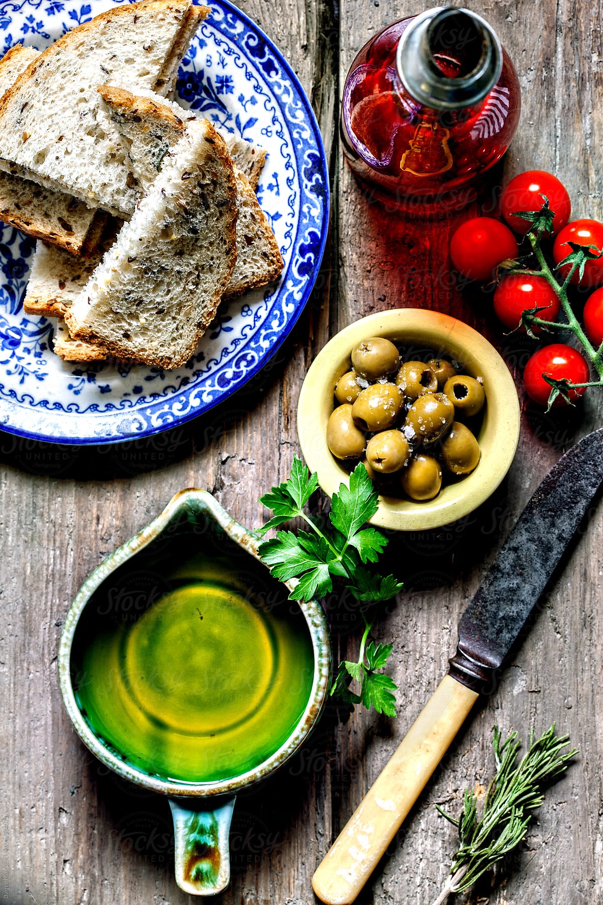 Food. olive oil,olives,tomato and bread on wooden table. Seen from above.