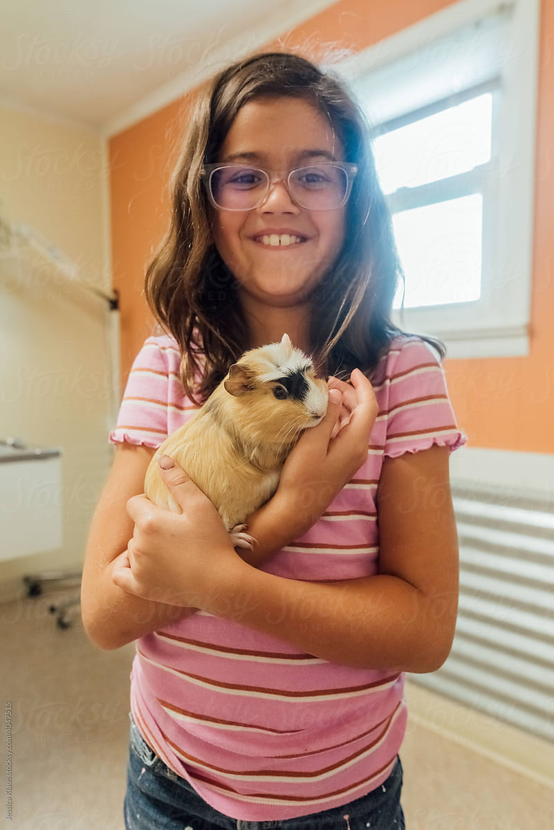 Girl proudly holding pet.