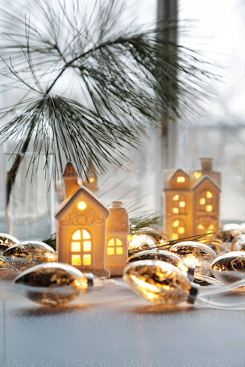 Ceramic houses with gold lights near window