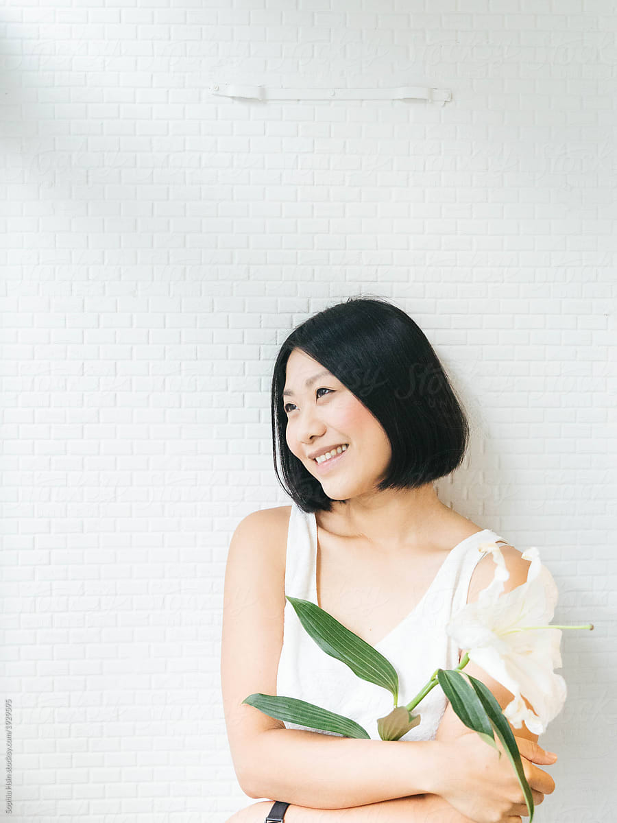 Minimalist portrait of girl holding flowers on white background