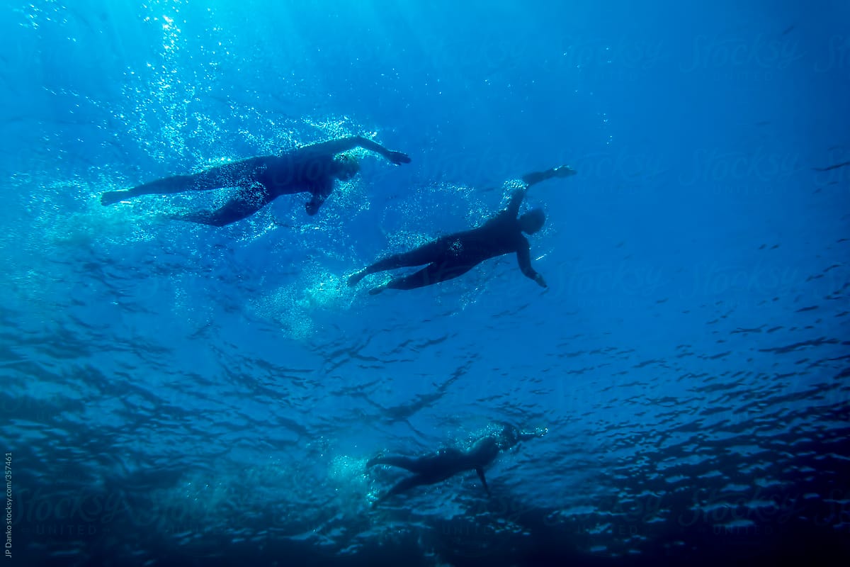 Triathlon Athletes During Swim Stage In Clear Blue Water Lake