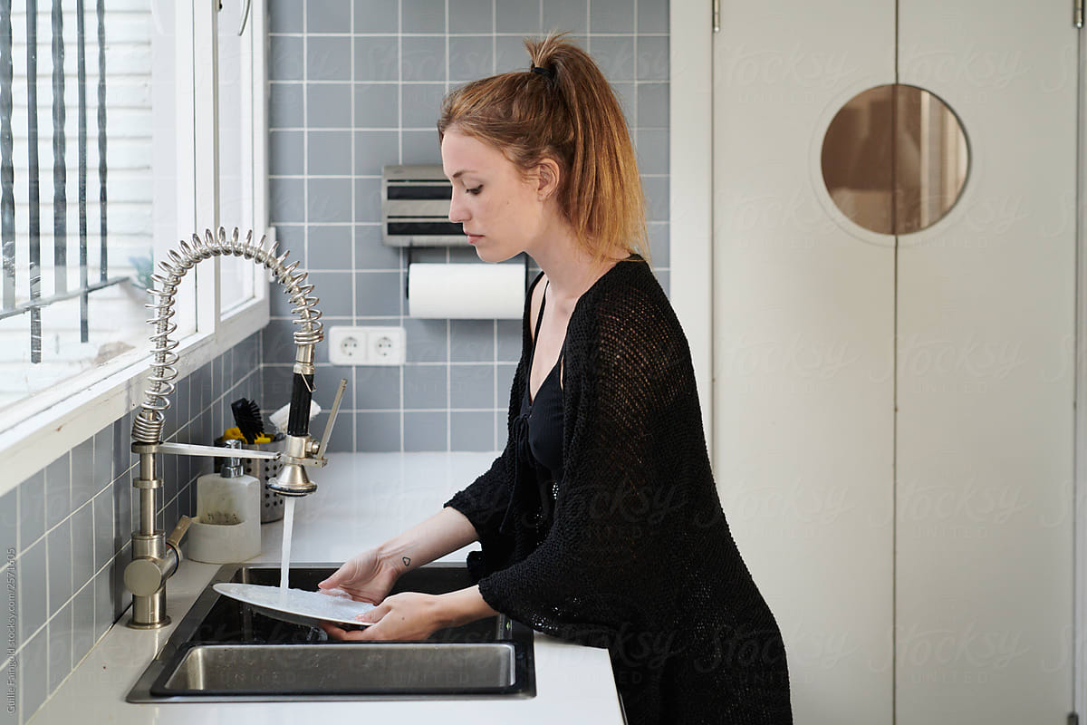 Young woman washing dish in the kitchen