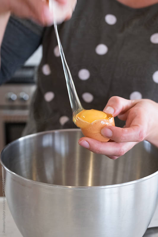 Home cook separating egg yollk for merengue mixture