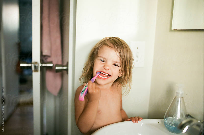 little girl brushes teeth