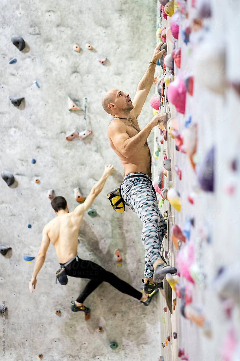 Two climbers exercising in climbing gym