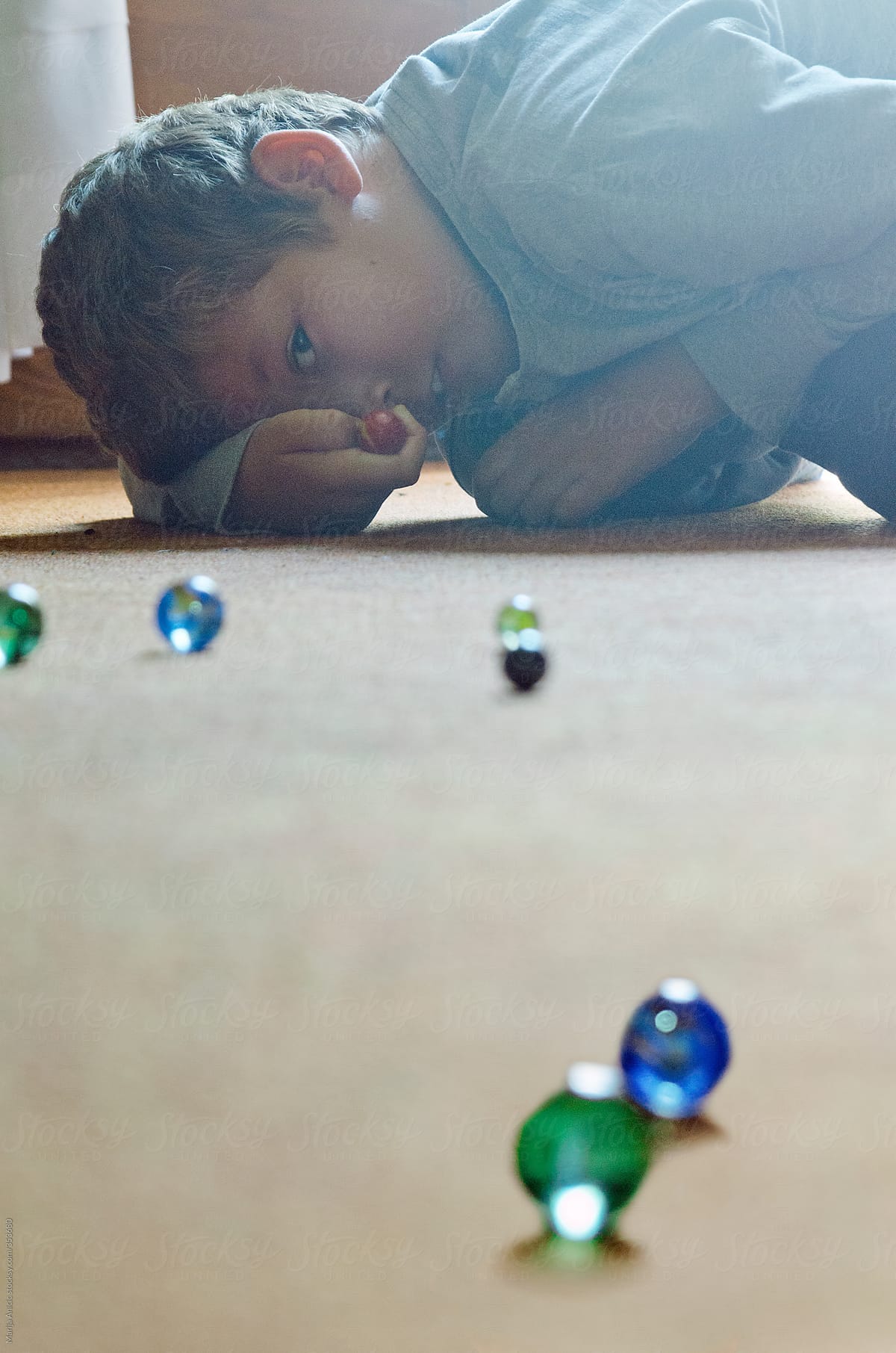 Boy playing with colorful marbles