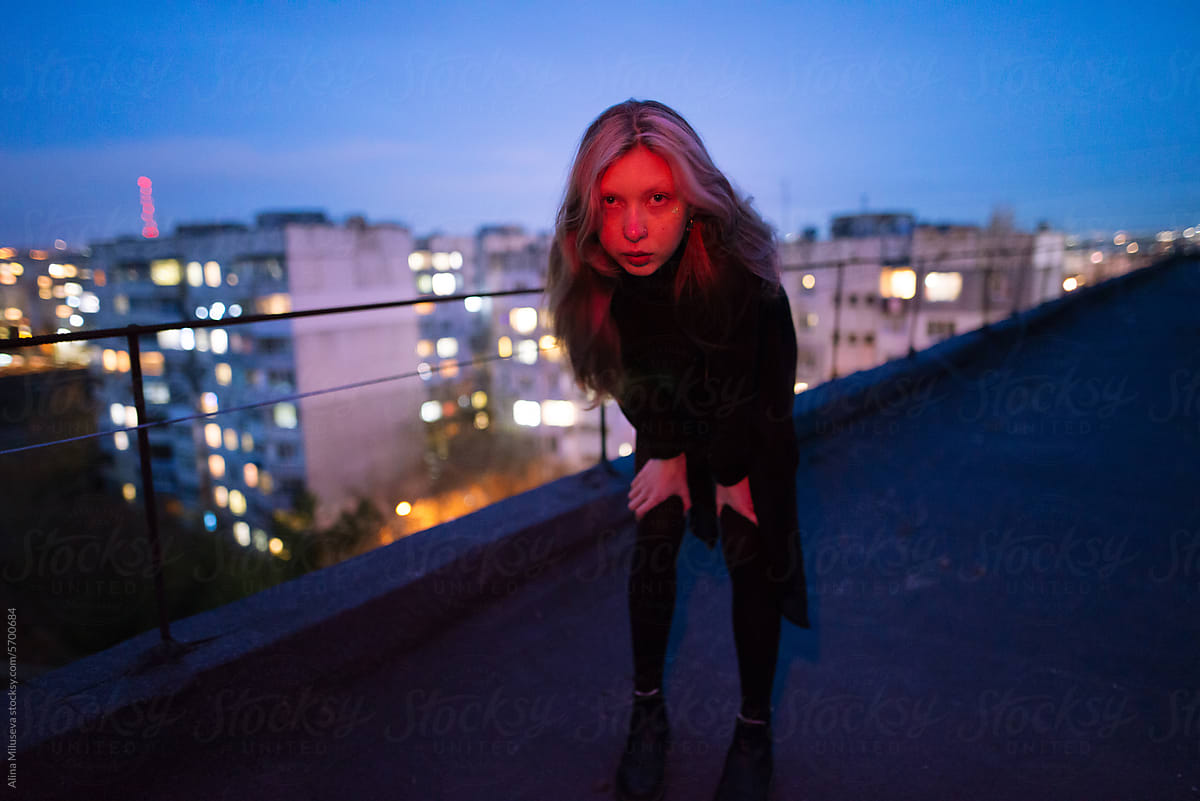 Night Portrait Of A Woman In Red Light On The Rooftop