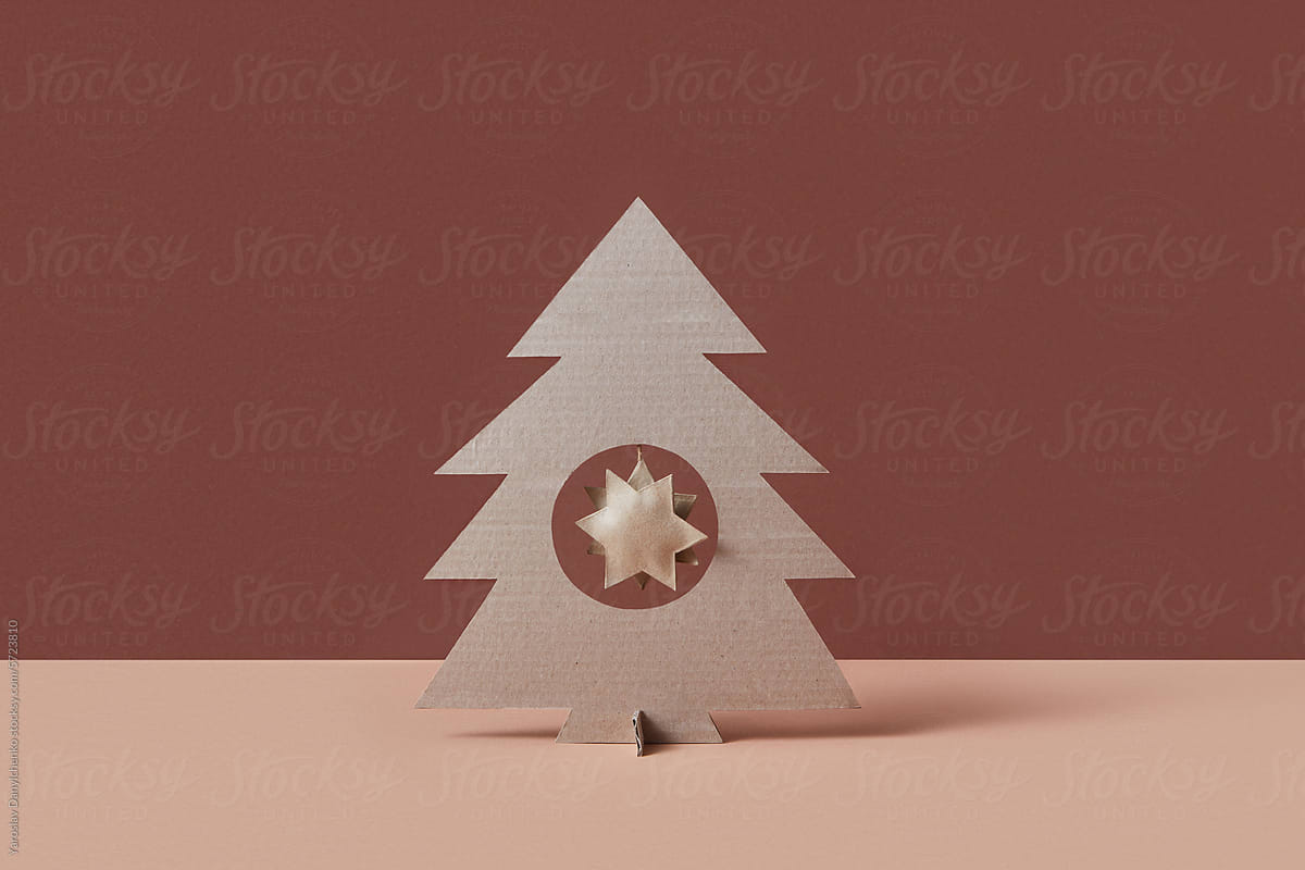 Papercraft Christmas tree with cardboard star hanging in middle