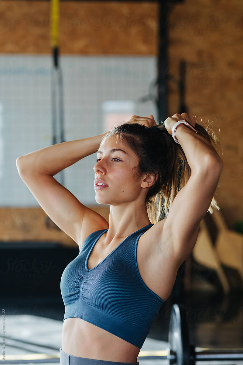 Woman Tying Hair in Gym