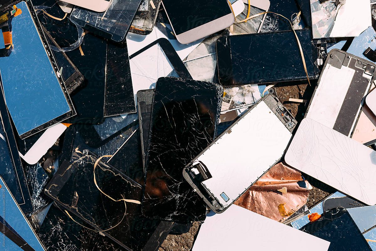 Broken cell phone screens and tablet on a pile