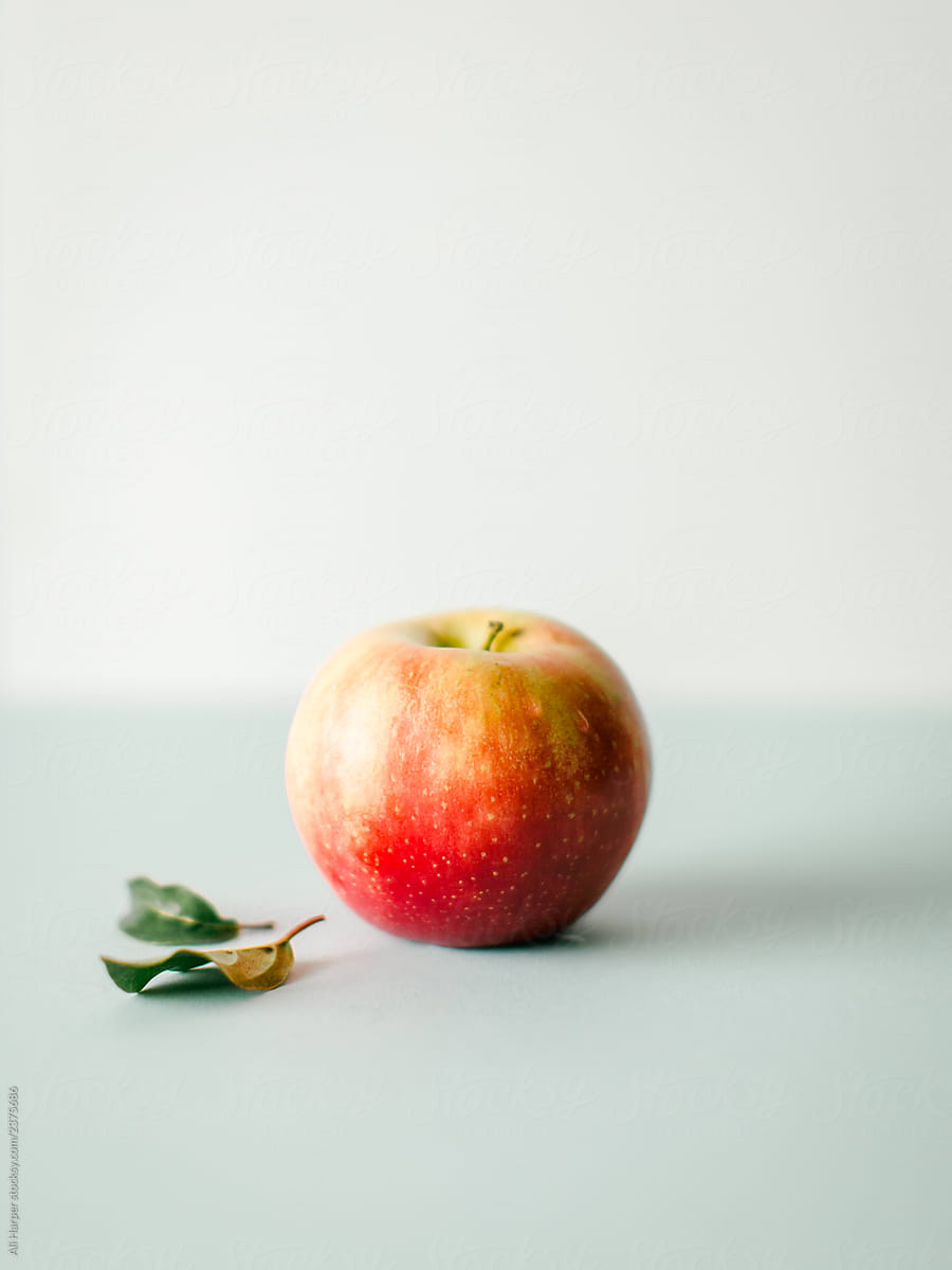 Single apple with leaf on countertop