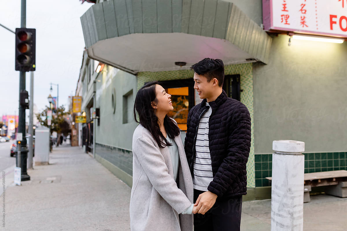 Young Asian Couple Hold Hands While on Date in Chinatown