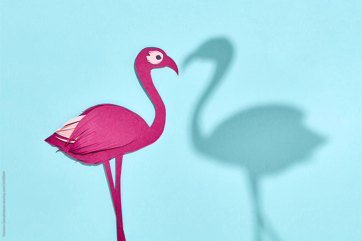 Colored pink handmade paper flamingo with own shadow on a pastel