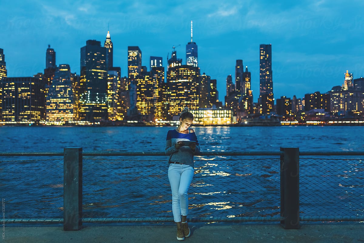 Young Woman Using a Digital Tablet for Discovering New York During The Night . US