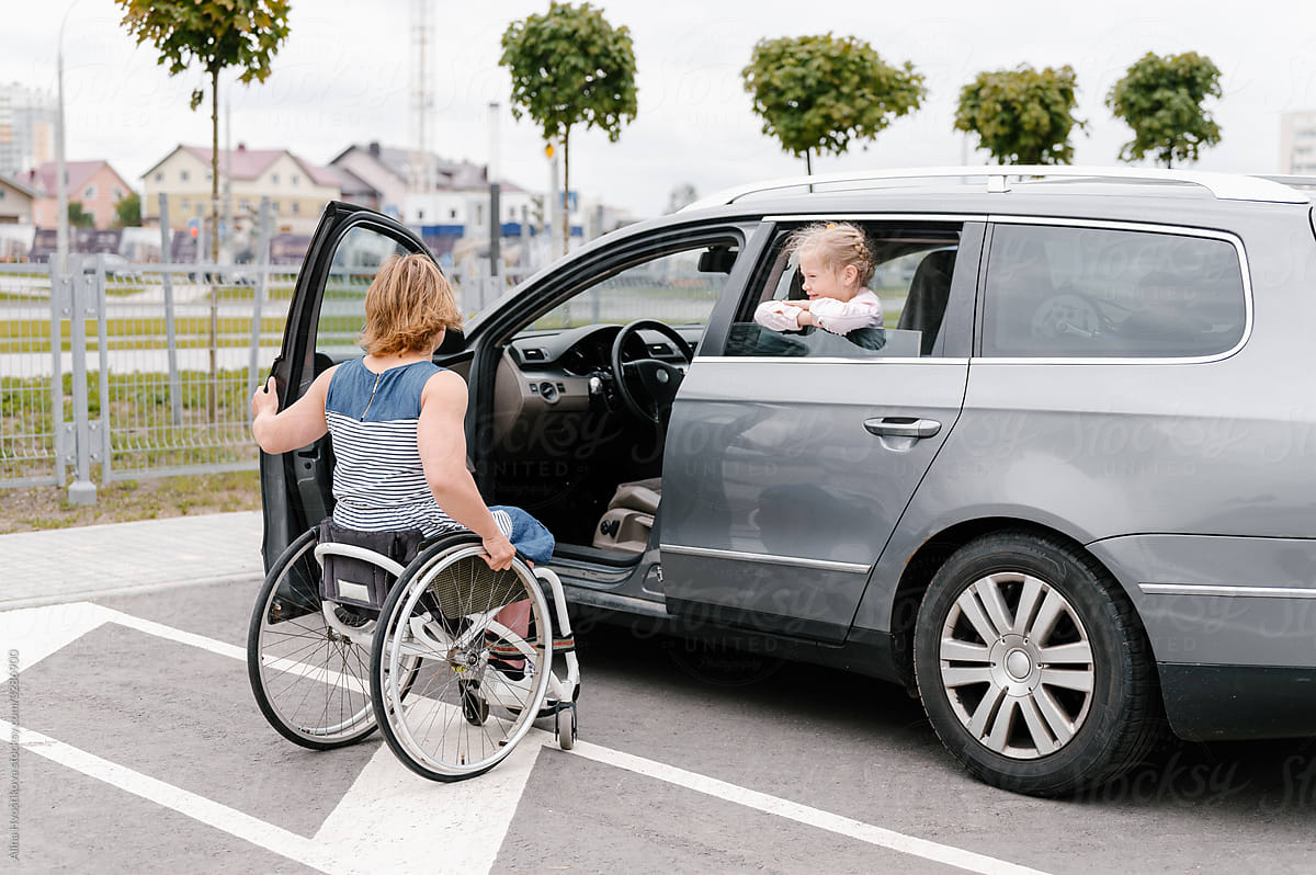 Mother on wheelchair getting into car