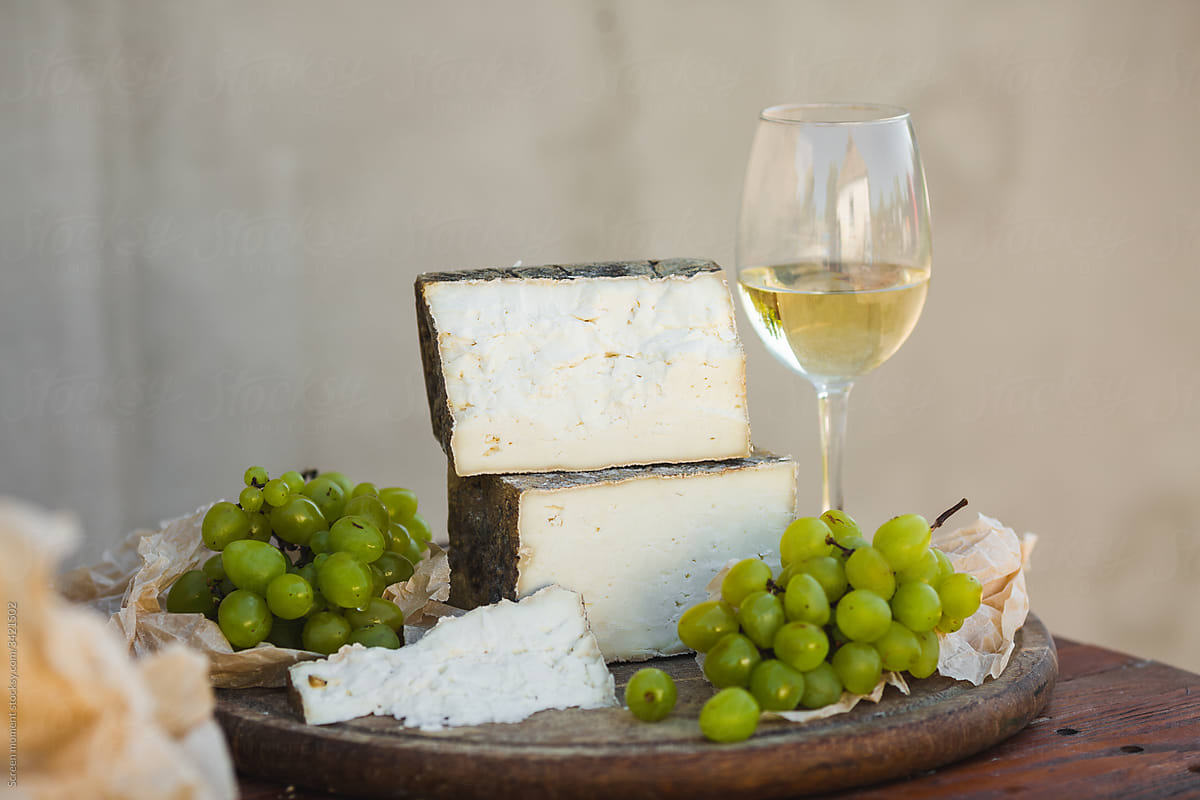 Goat cheese and glass of wine on rustic background